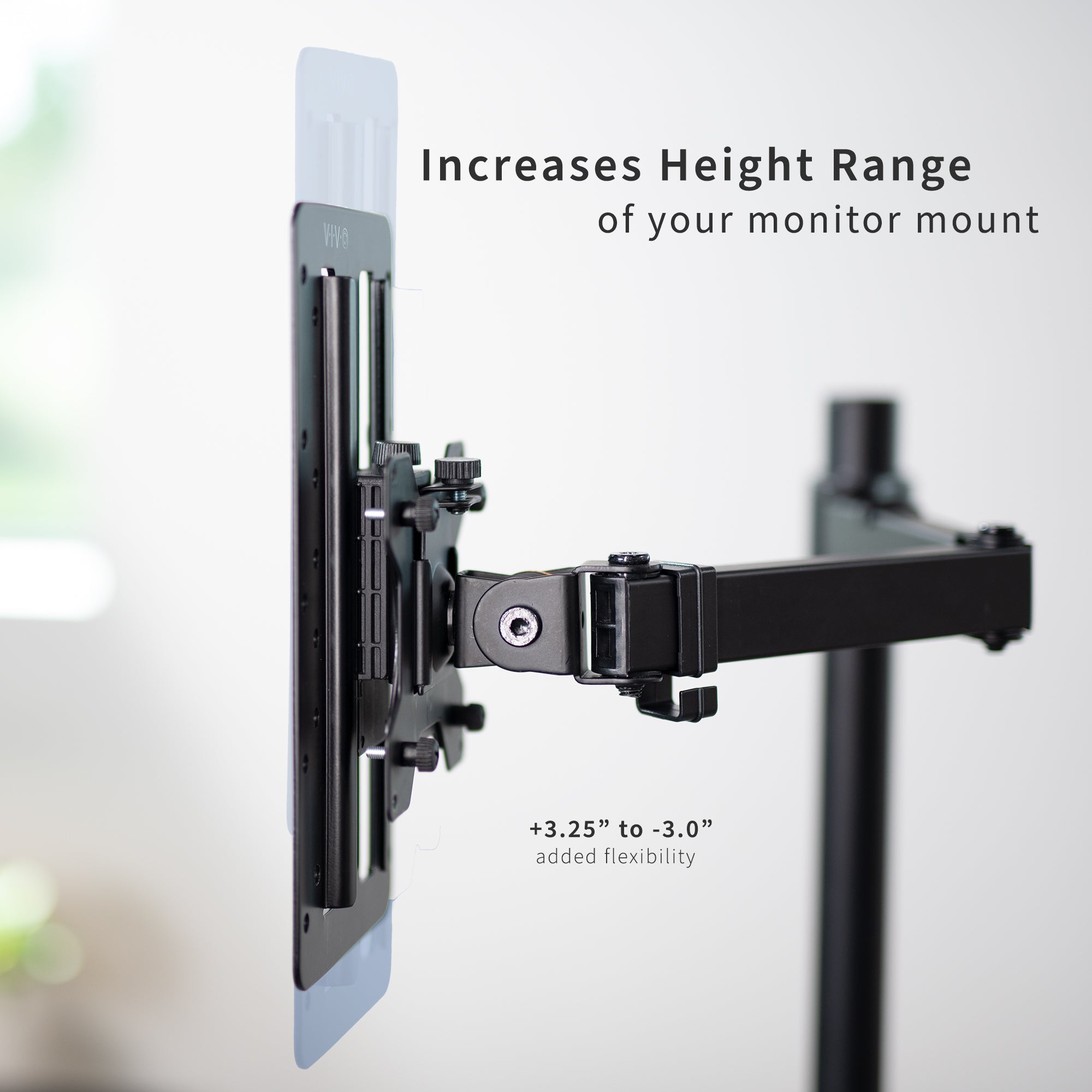 Height-adjustable Vesa adapter attached to a monitor on a desk with office background