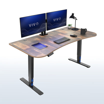 A modern curved standing desk with a reclaimed wood top and black metal legs, shown with two computer monitors, a keyboard, a mouse, a tablet, and a desk lamp on a clean white background.