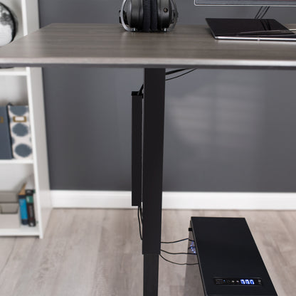 PC cables running up through a cable strip on the desk leg.