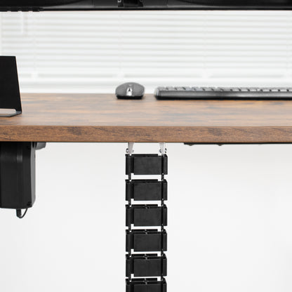 Vertebrae cable management attached to a walnut-colored desktop.