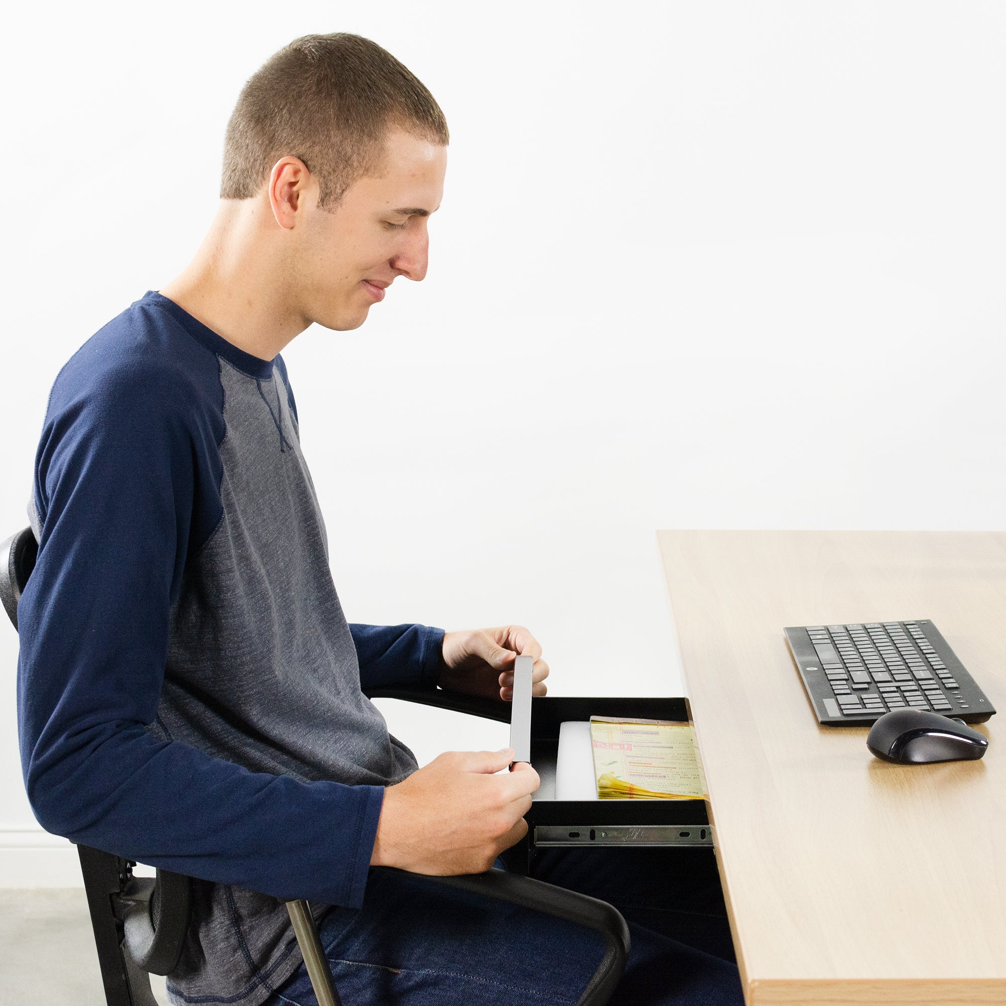 Sitting use of under-desk storage drawer with a smooth sliding mechanism.