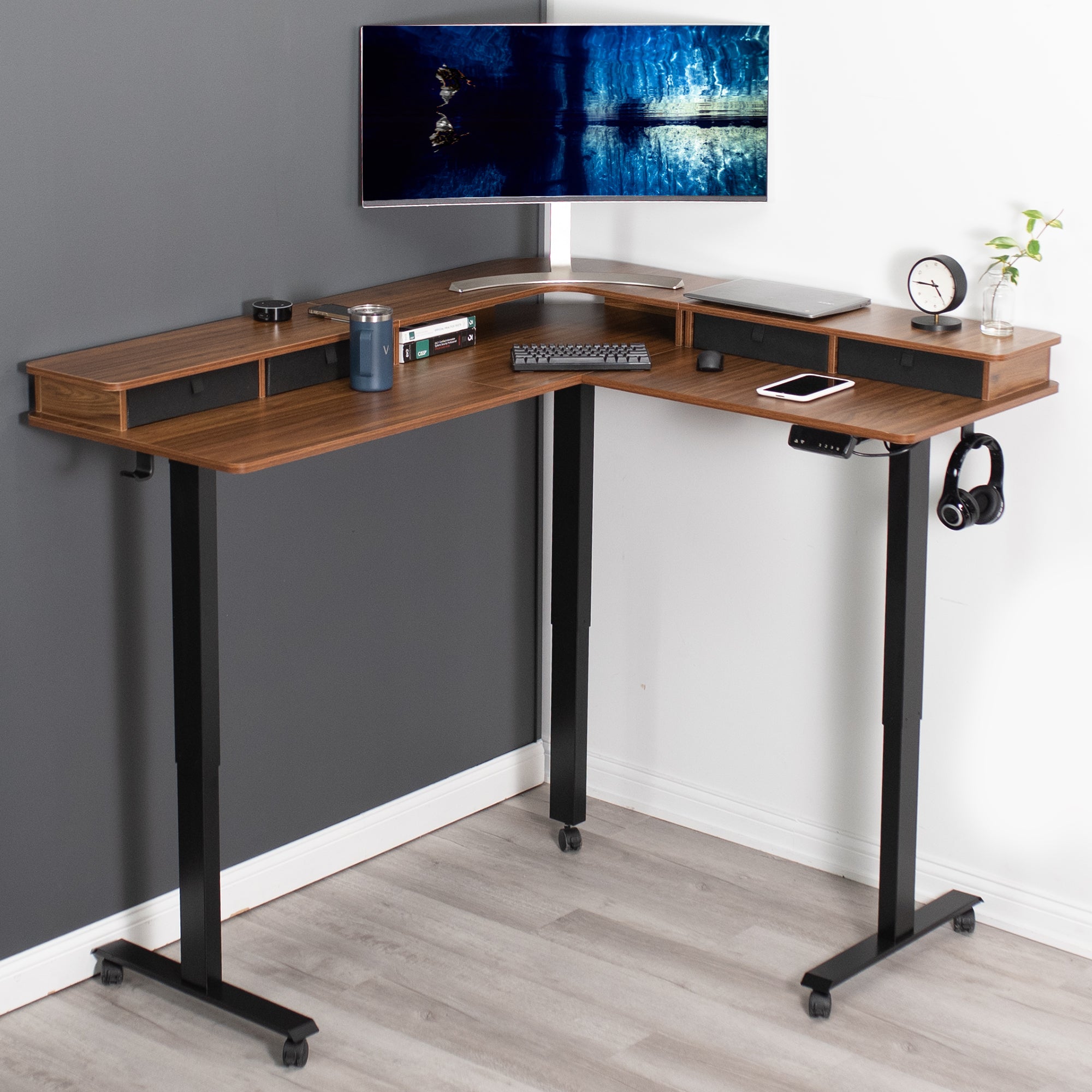 Dual tier height adjustable electric corner desk with storage drawers and wheels.