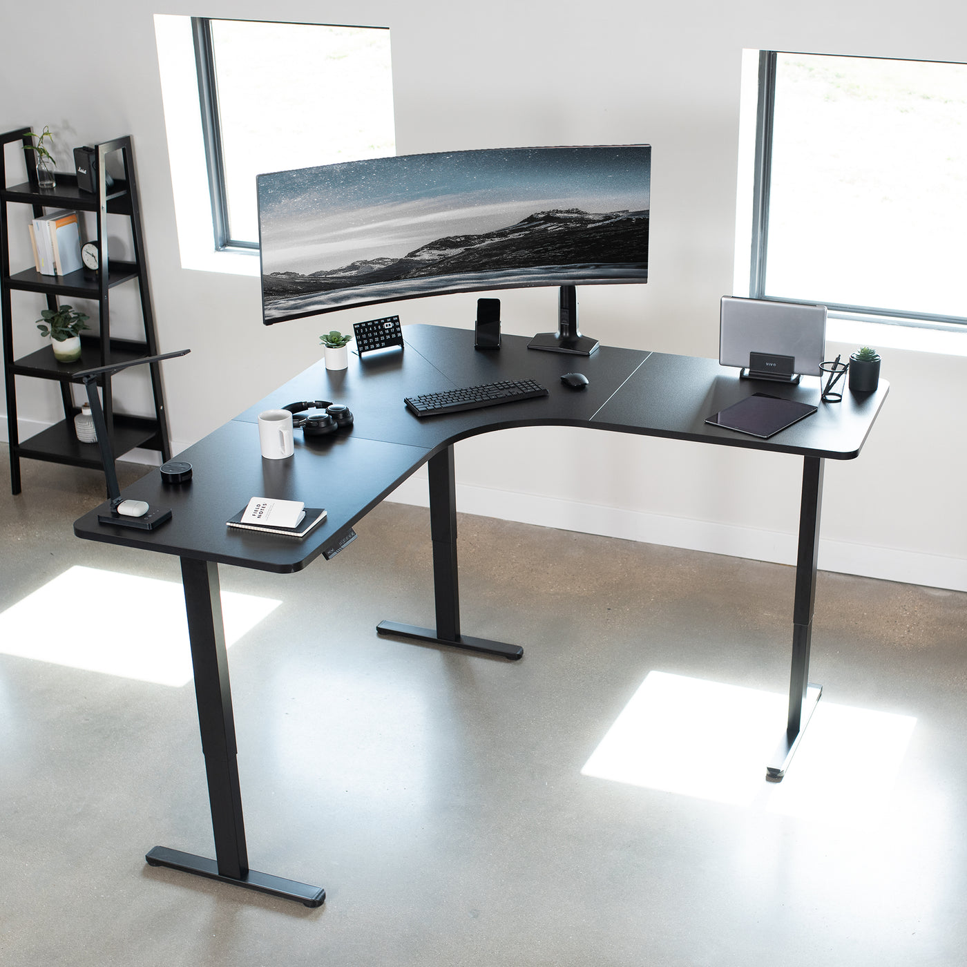 Fully furnished office space inspiration with a black L-shaped electric desk.