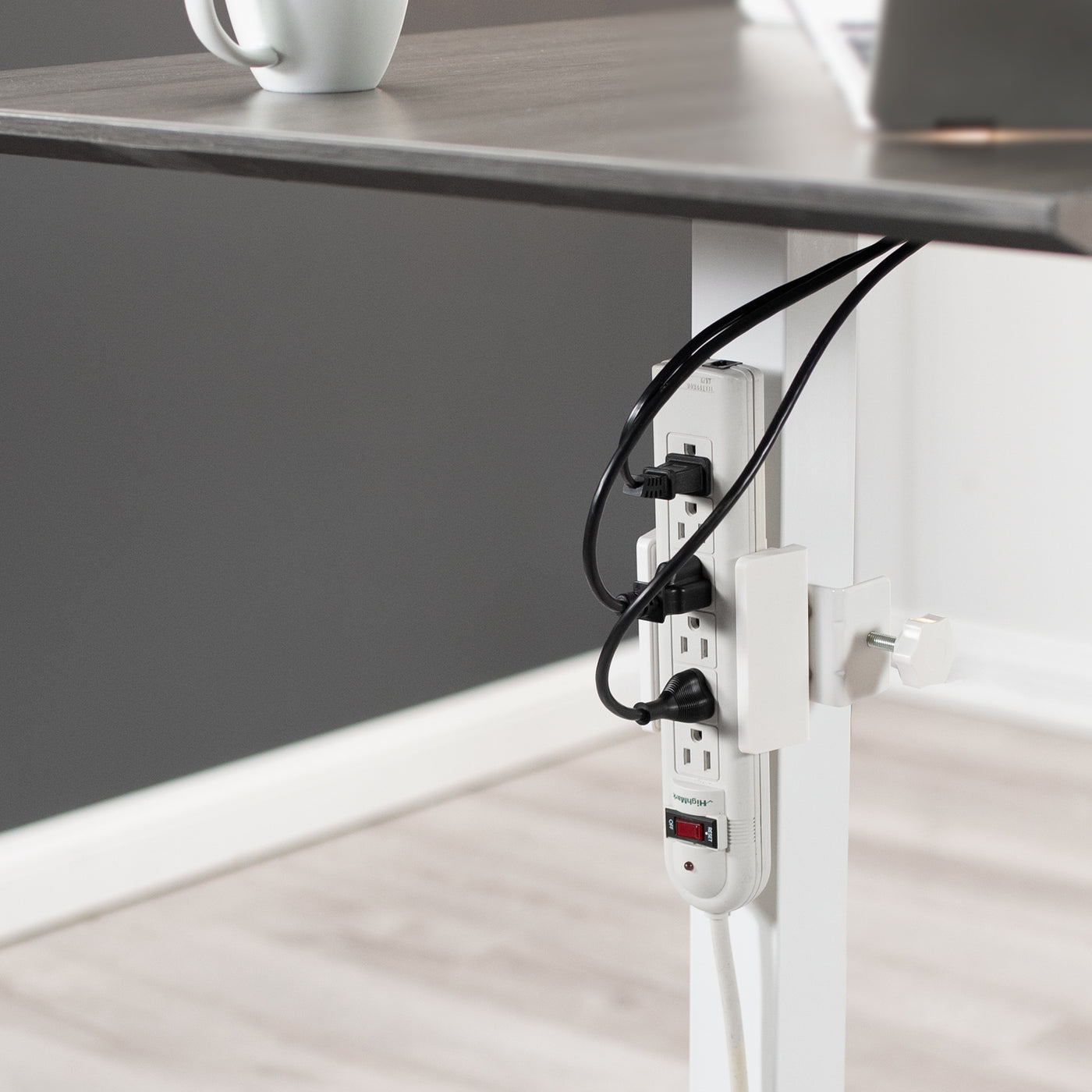 Desk leg with C-clamp under desk power strip holder.