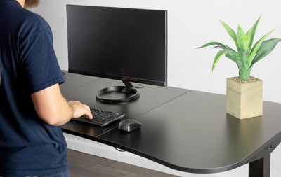 Mad standing at a desk working on a modern desktop.