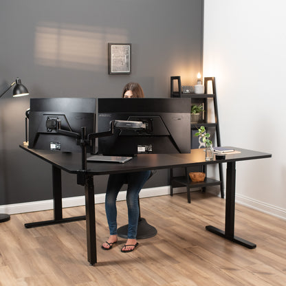 A person working in a modern office setup with a curved L-shaped corner desk.