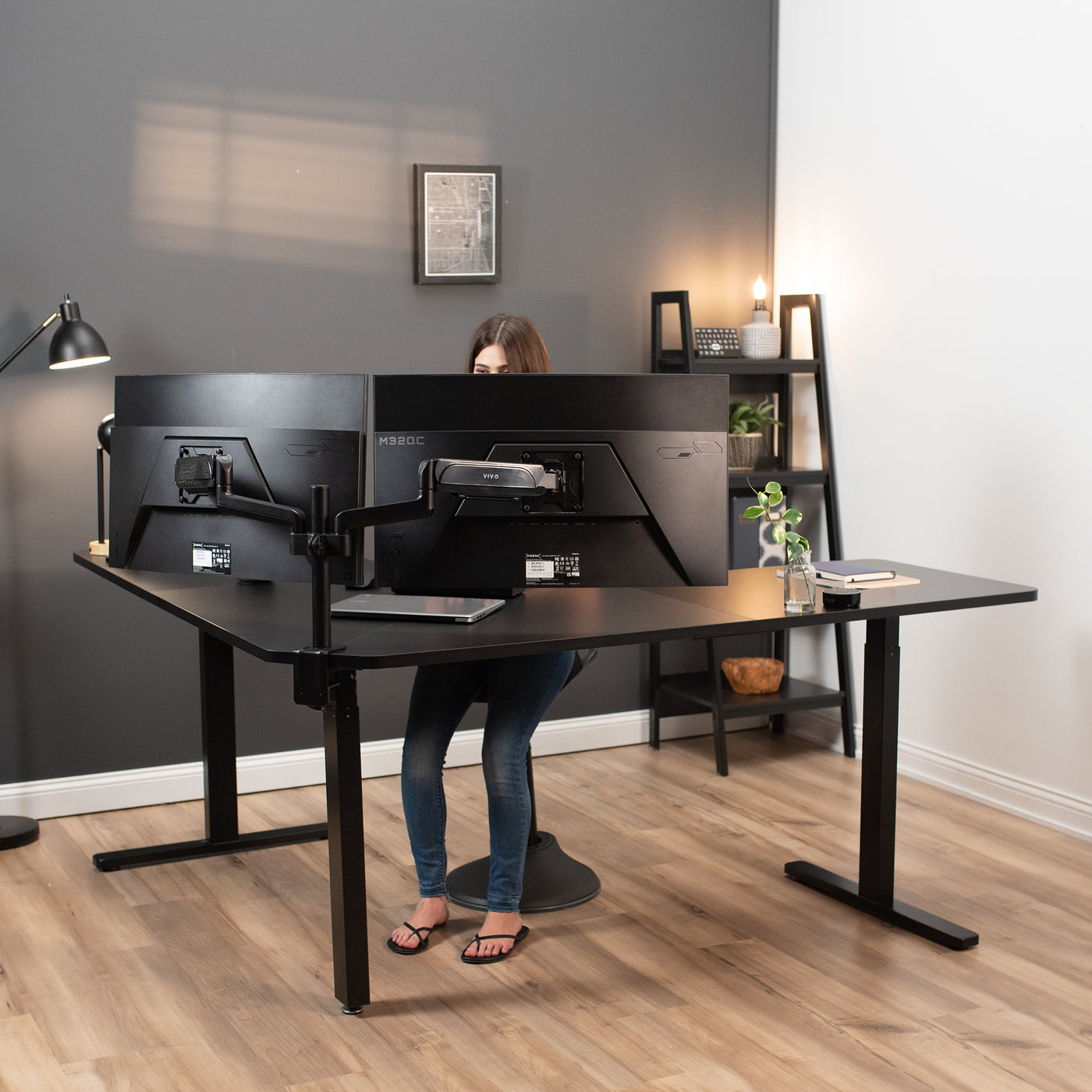 A person working in a modern office setup with a curved L-shaped corner desk.