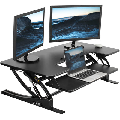 Dual-tier pneumatic assist desk converter with keyboard and mouse tray.
