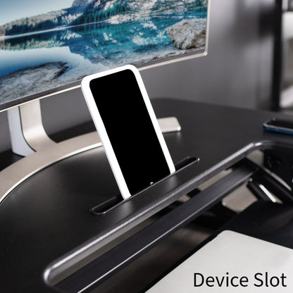 Designated device slot located center front on the top layer of desk riser.