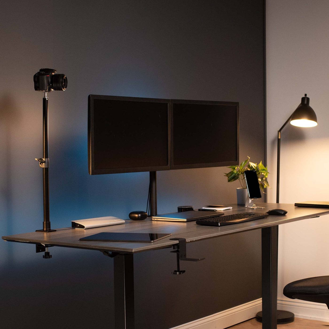 Modern office space with dual monitor mount and single pole camera mount for videoing.