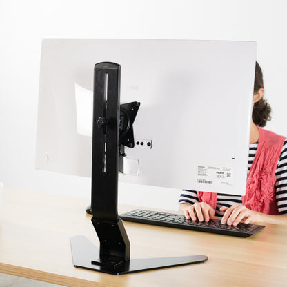 A woman working at a large office desk with a Samsung series CF591 attached to a mount through a specially designed bracket.