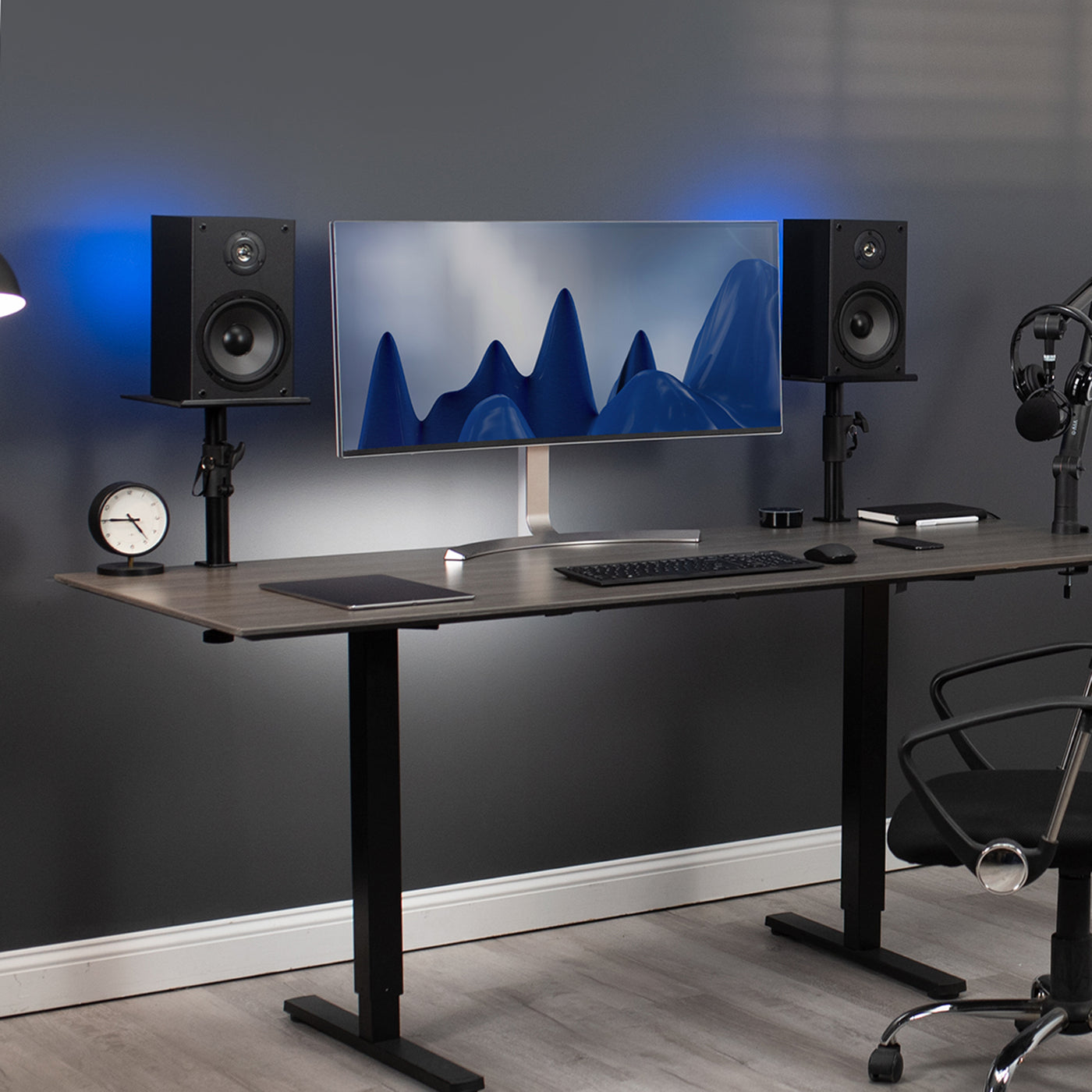 Modern clamp-on speaker stands on both sides of a large monitor.