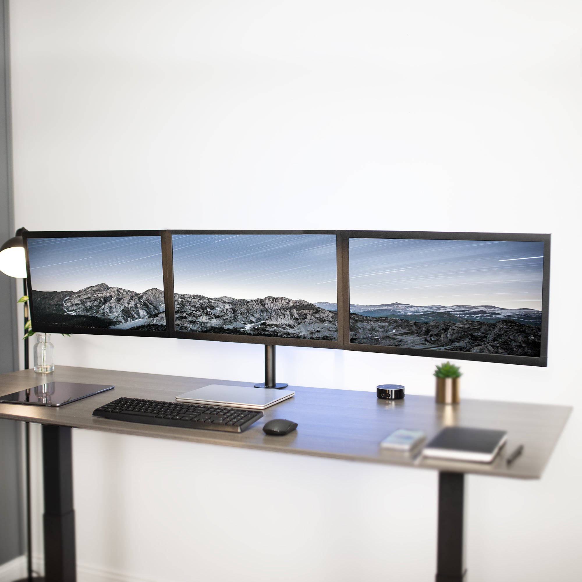 Sturdy height adjustable triple monitor desk mount.